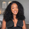 Model wearing a natural-black layered curly bob with a side part, viewed from the front.