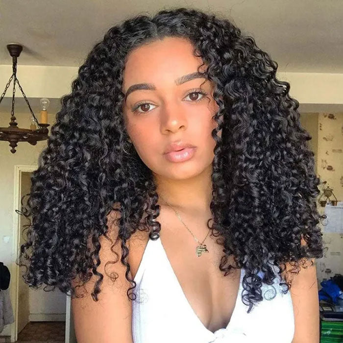 Front view of a model wearing dark defined curls with a center part.